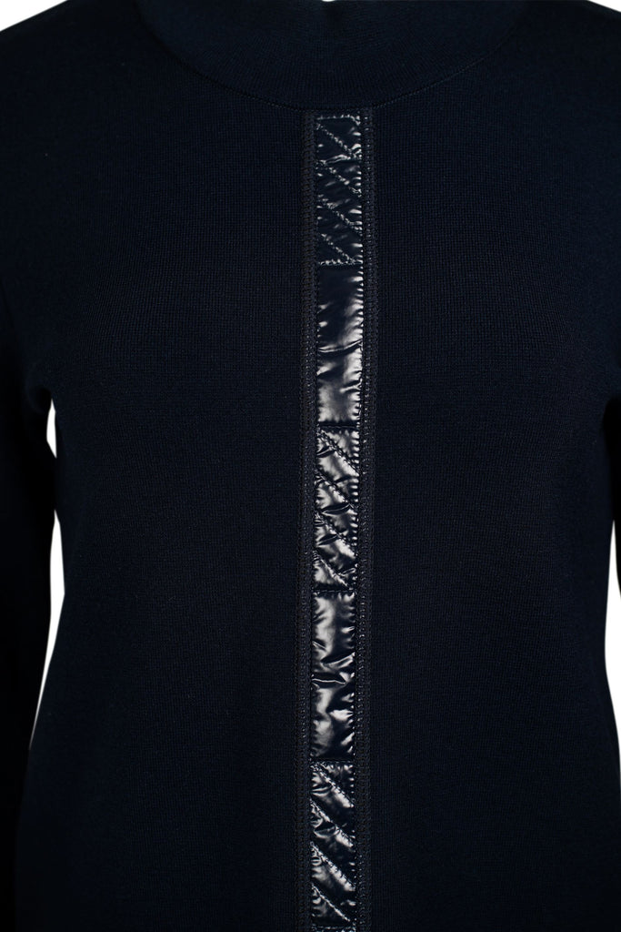 Detailansicht vorne: Dunkelblauer Damenpullover mit Stehkragen und langer Arm. Auf der Vorderseite verläuft mittig eine glänzende, dunkelblaue Zierleiste als dekoratives Element. Der Pullover ist schlicht geschnitten und figurbetont.“