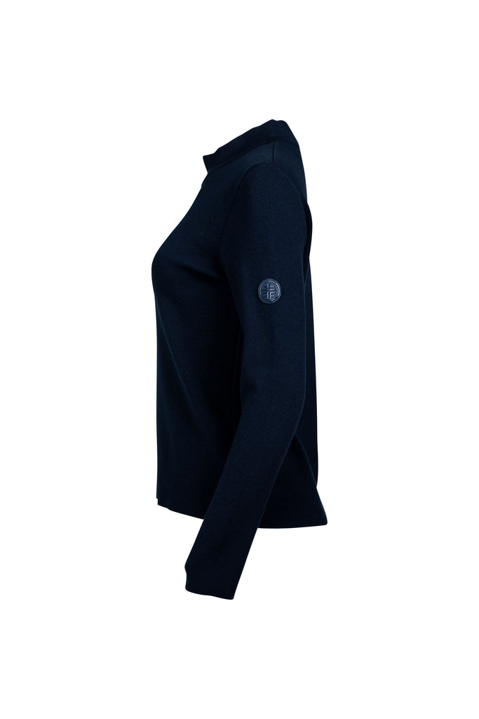 Detailansicht Seite: Dunkelblauer Damenpullover mit Stehkragen und langer Arm. Auf der Vorderseite verläuft mittig eine glänzende, dunkelblaue Zierleiste als dekoratives Element. Der Pullover ist schlicht geschnitten und figurbetont.