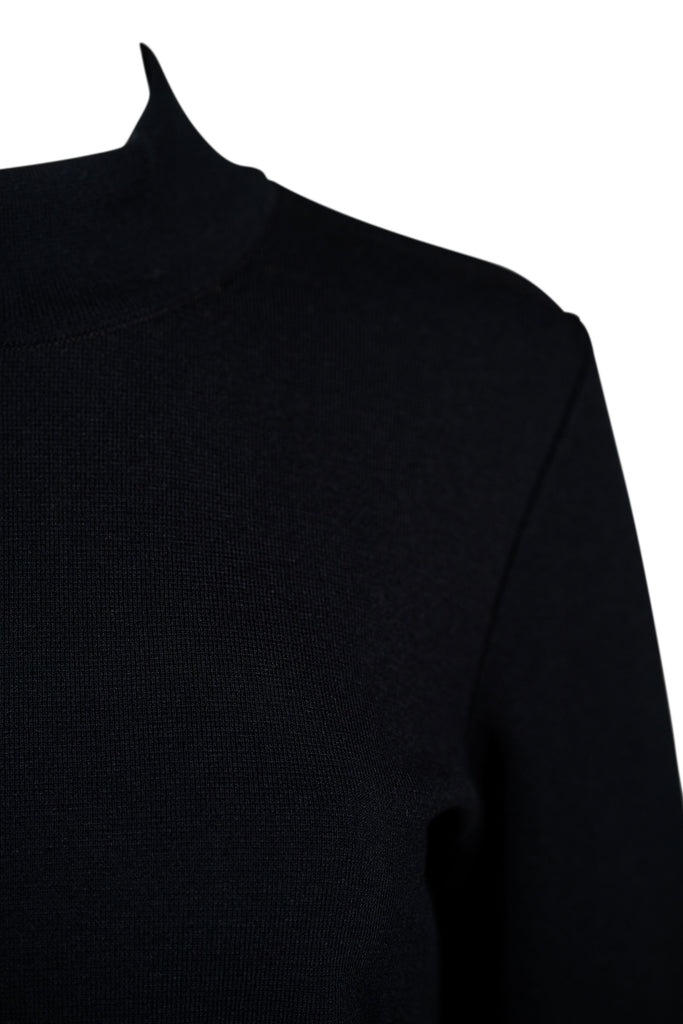 Detailansicht: Schwarzer Damenpullover mit Stehkragen und langer Arm. Der Schnitt ist schlicht und figurbetont, ohne sichtbare Verzierungen oder Muster. Der Pullover wirkt klassisch und minimalistisch.