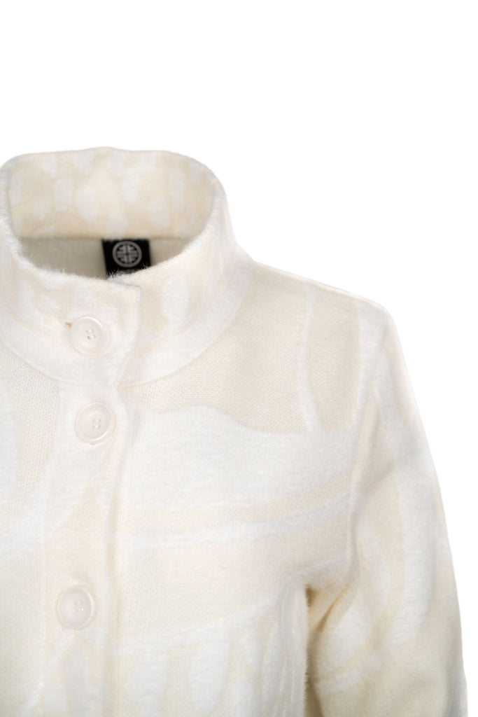 Detailansicht Kragen - Cremefarbene Strickjacke mit Stehkragen, durchgehender Knopfleiste und aufgesetzten Taschen. Strukturierte Strickmuster sorgen für einen hochwertigen, gemütlichen Look – ideal für kühle Tage.