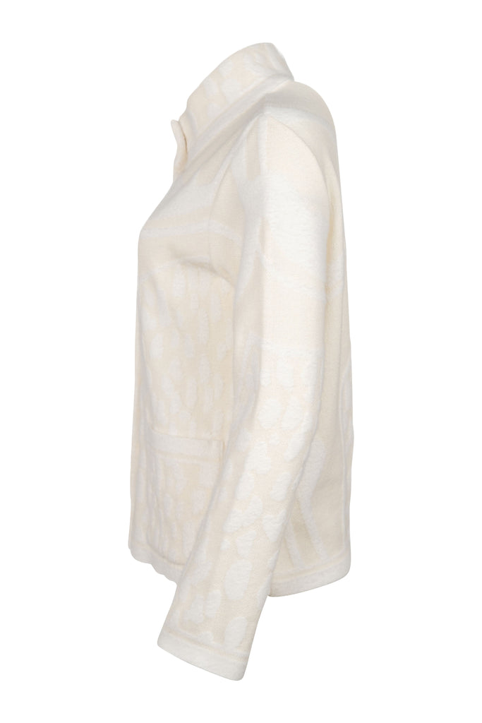 Seitenansicht - Cremefarbene Strickjacke mit Stehkragen, durchgehender Knopfleiste und aufgesetzten Taschen. Strukturierte Strickmuster sorgen für einen hochwertigen, gemütlichen Look – ideal für kühle Tage.