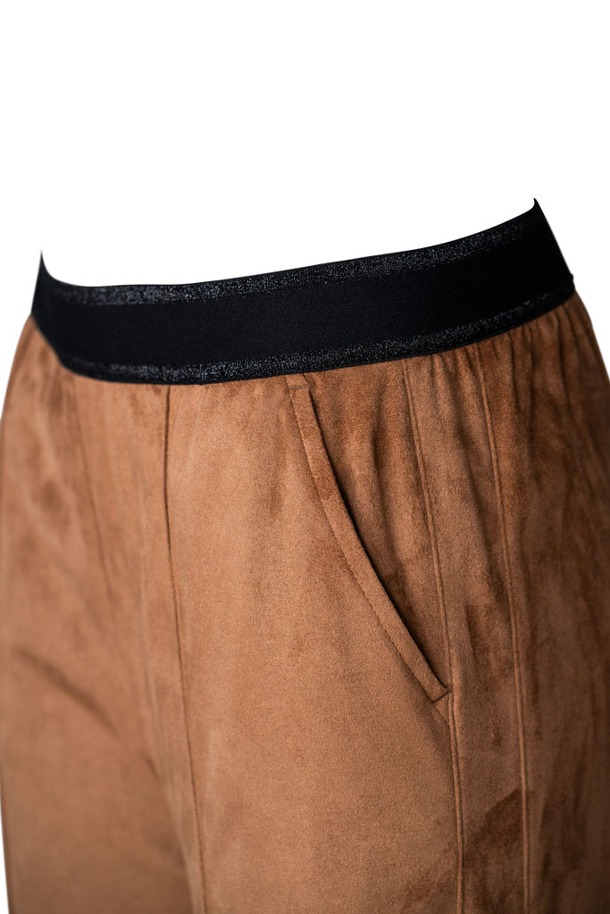 Detailansicht: Braune Damenhose mit weitem Bein und dezentem Glanz. Die Hose hat einen elastischen, schwarzen Bund und sichtbare Bügelfalten auf der Vorderseite. Der Schnitt ist locker und elegant – geeignet für einen entspannten, aber stilvollen Look.