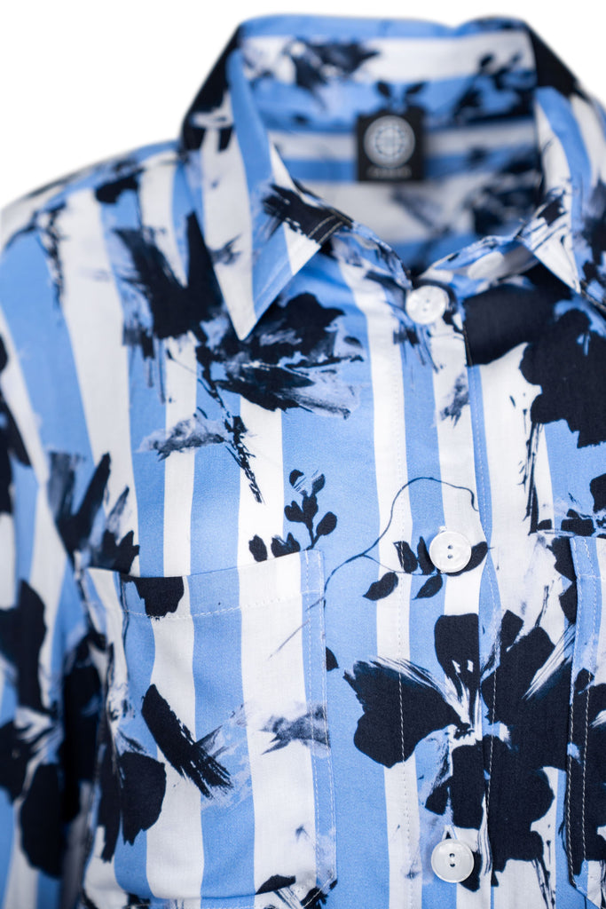 Detailansicht Kragen - Damenbluse mit langen Ärmeln und durchgehender Knopfleiste. Gestreiftes Muster in Hellblau und Weiß, kombiniert mit floralen, dunkelblauen Prints. Zwei Brusttaschen mit Klappen – modisch und auffällig.