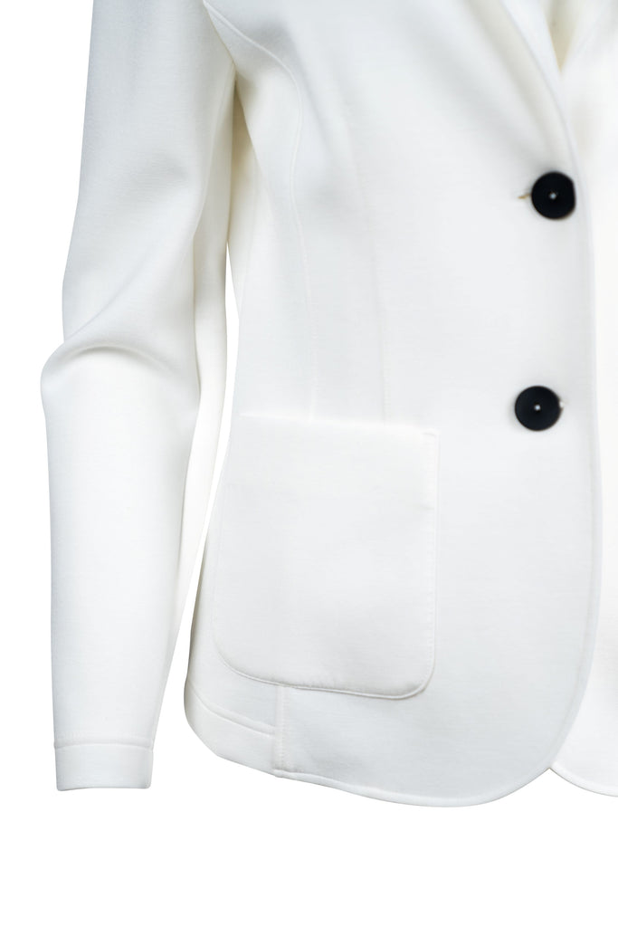Detailansicht Knopfleiste - Eleganter Damenblazer in Weiß mit taillierter Passform, zwei schwarzen Knöpfen und schwarzen Zierstreifen am Reverskragen. Ausgestattet mit zwei aufgesetzten Taschen, ideal für formelle Anlässe.
