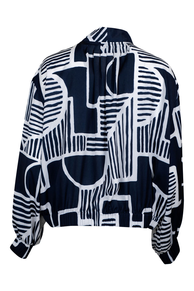 Ansicht Rückseite - Damenjacke mit durchgängigem Reißverschluss und Stehkragen in Dunkelblau mit großflächigem, abstraktem Weißdruck. Die Jacke hat lange Ärmel mit Gummizug am Handgelenk und ein modernes, künstlerisches Design. Ideal für ein Statement-Outfit.