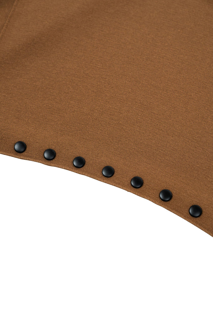 Brauner Strickschal in asymmetrischer Form, verziert mit einer Reihe schwarzer Ziernieten entlang einer Seite. Der Schal besteht aus leicht strukturiertem Material und lässt sich locker um den Hals legen oder kreativ drapieren.