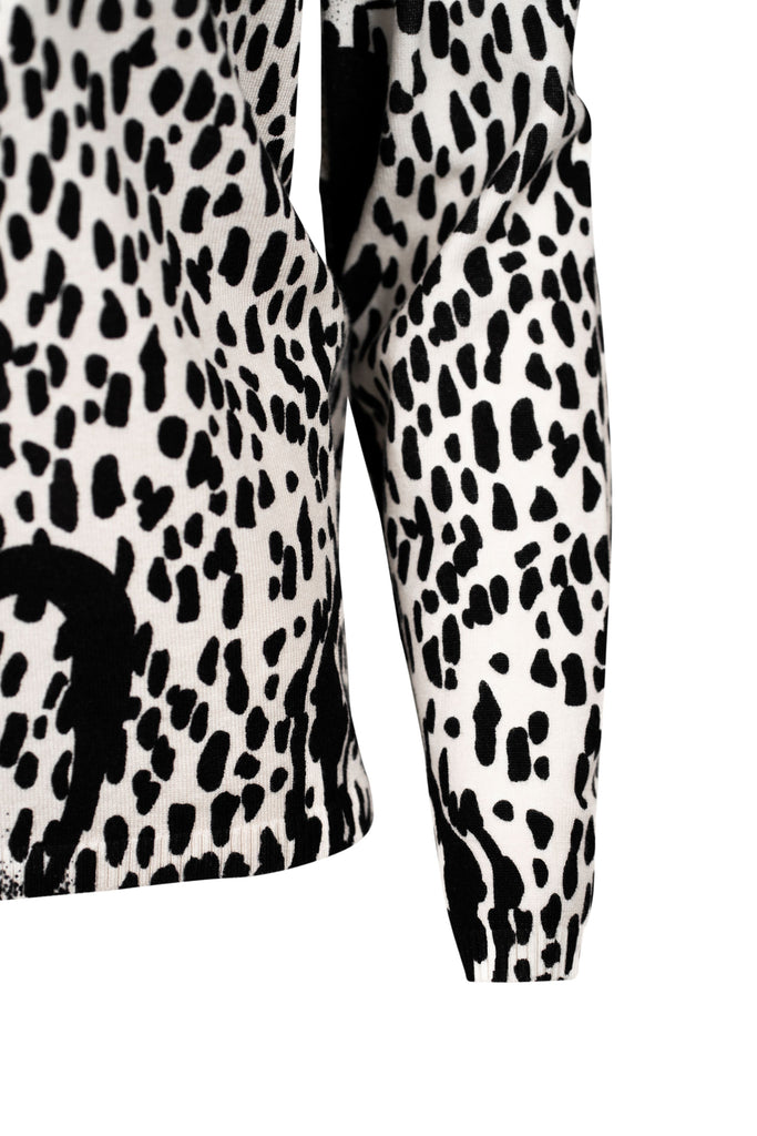 Detailansicht Ärmel - Langarmshirt mit Stehkragen und auffälligem Schwarz-Weiß-Print. Das Design kombiniert abstrakte Linien mit Animal-Print-Elementen und floralen Details zu einem modernen, grafischen Statement-Piece.