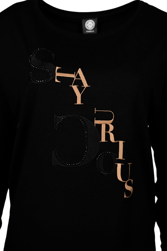Schwarzes Langarmshirt mit Rundhalsausschnitt. Auffällig ist der elegante Schriftzug "Stay Curious" in Schwarz und Kupfer, teilweise verziert mit funkelnden Strasssteinen. Ein modischer und komfortabler Look für Freizeit und Alltag.