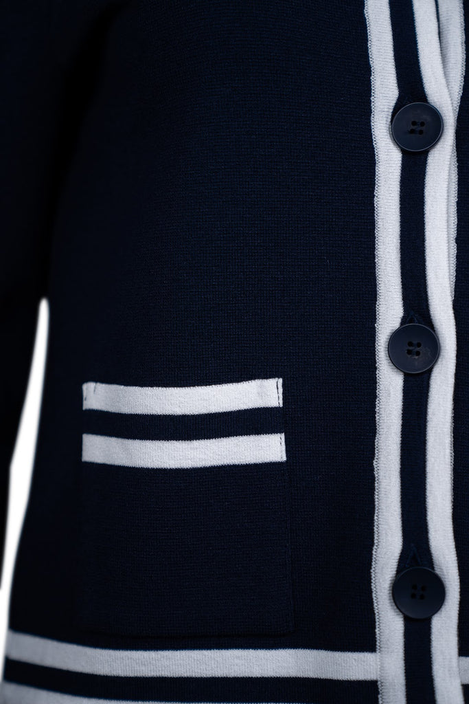 Detailansicht Knopfleiste - Kurzer Damen-Cardigan in Dunkelblau mit weißen Kontraststreifen an Knopfleiste, Rundhalsausschnitt, Taschen, Saum und Ärmelabschlüssen. Klassisches Design mit Knopfverschluss und aufgesetzten Taschen.